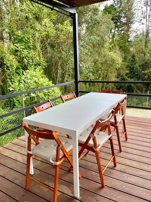 a white table and chairs on a deck at Casa Moderna en el Bosque Jacuzzi y Deck Privado in Mazo