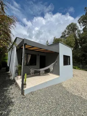 a small white house with a hammock in it at Casa Moderna en el Bosque Jacuzzi y Deck Privado in Mazo