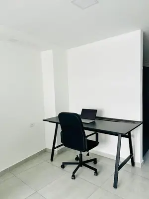 a black desk with a chair and a laptop on it at Central apartment in Bello in Bello
