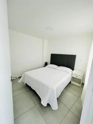 a bedroom with a white bed with a black headboard at Central apartment in Bello in Bello
