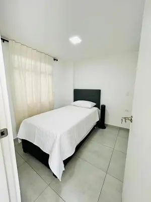 a white bedroom with a white bed in a room at Central apartment in Bello in Bello
