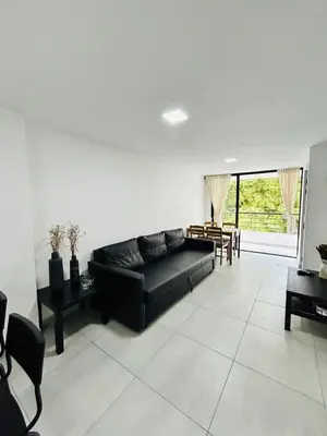 a living room with a black couch and a table at Central apartment in Bello in Bello