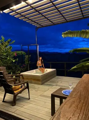 a woman sitting in a bath tub on a patio at Cabañas Flor Del Monte in Sopetran