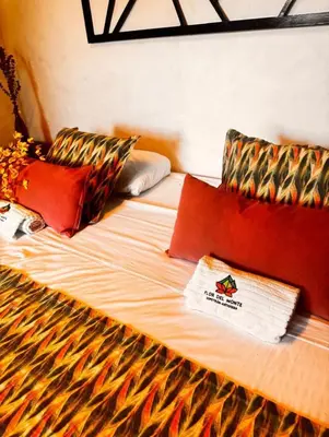 a large bed with colorful pillows on it at Cabañas Flor Del Monte in Sopetran