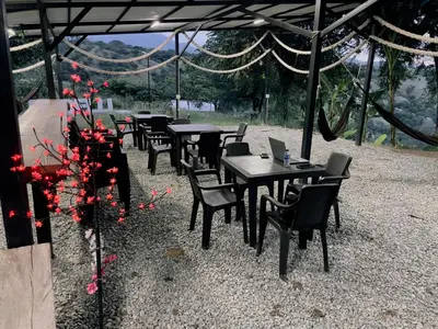 a group of tables and chairs with red flowers at Cabañas Flor Del Monte in Sopetran