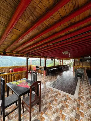 a room with a table and chairs and a roof at piedras del ocaso manizales in Manizales