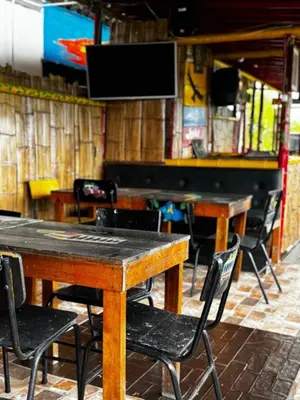 a dining room with tables and chairs and a television at piedras del ocaso manizales in Manizales