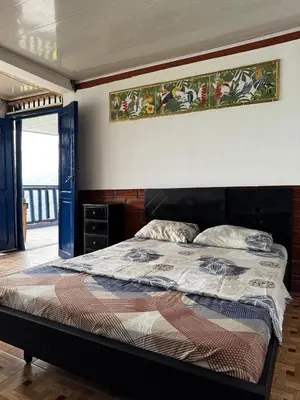 a bedroom with a bed with a painting on the wall at piedras del ocaso manizales in Manizales