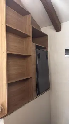 a kitchen with a black refrigerator and wooden shelves at Apartamento tipo loft in Guarne