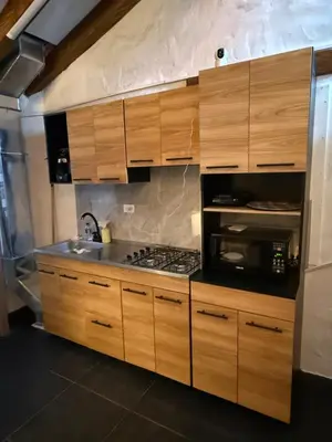 a kitchen with wooden cabinets and a stove top oven at Apartamento tipo loft in Guarne