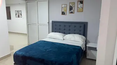 a bed with a blue blanket and pillows in a room at Casa Primaveral Espaciosa Cerca al Estadio in Medellín