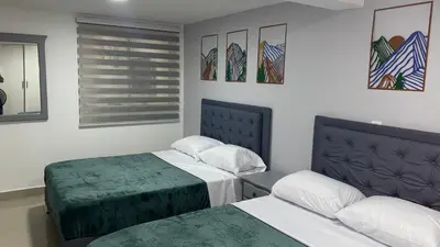 a hotel room with two beds and a window at Casa Primaveral Espaciosa Cerca al Estadio in Medellín