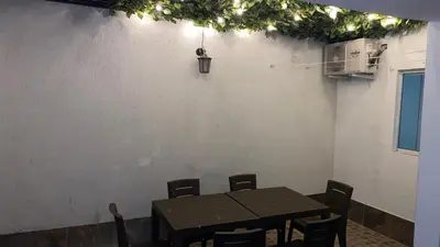 a dining room table with chairs and a white wall at Casa Primaveral Espaciosa Cerca al Estadio in Medellín