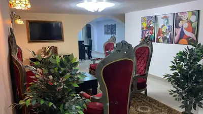 a living room with chairs and a flat screen tv at Casa Primaveral Espaciosa Cerca al Estadio in Medellín