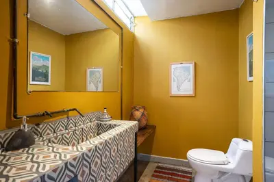 a bathroom with a sink and a toilet and a mirror at Bright Colonial 5BR House with Balcony in Medellín