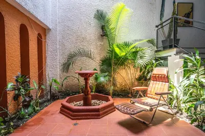 a patio with a fountain and a chair and plants at Bright Colonial 5BR House with Balcony in Medellín