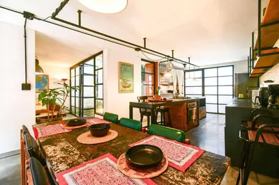 a dining room with a table and a kitchen at Bright Colonial 5BR House with Balcony in Medellín