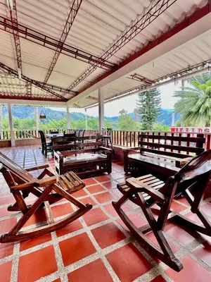 a room with chairs and tables on a tile floor at Finca La Carmelita Casa Campestre con Piscina y entre Montañas a sólo minutos de Santa Rosa de Cabal in Santa Rosa de Cabal