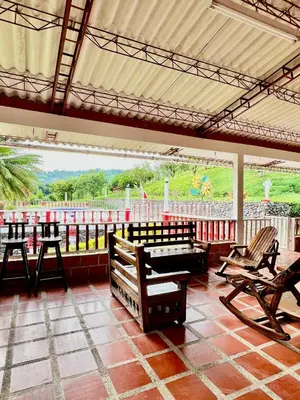 a patio with benches and a view of a field at Finca La Carmelita Casa Campestre con Piscina y entre Montañas a sólo minutos de Santa Rosa de Cabal in Santa Rosa de Cabal