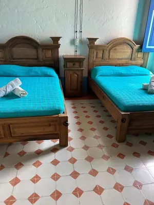 a bedroom with two beds with blue sheets at San José del refugio in Jericó