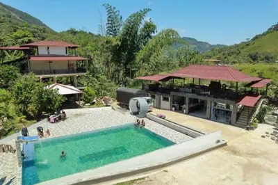 a large swimming pool in front of a building at Hostal Manantiales La Esperanza in Cocorná