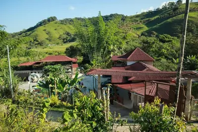 an image of a house with mountains in the background at Hostal Manantiales La Esperanza in Cocorná