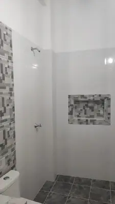 a white bathroom with a shower and a toilet at Hostal Manantiales La Esperanza in Cocorná