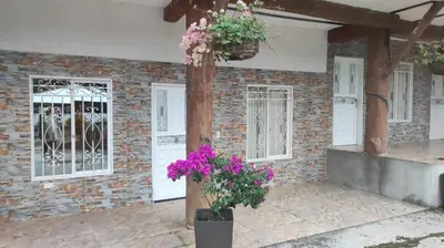 a house with flowers in a courtyard at Hostal Manantiales La Esperanza in Cocorná