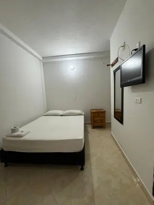 a small bedroom with a bed and a mirror at Hotel Real Alejandria in Alejandría