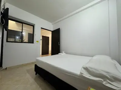 a bedroom with a large white bed with a window at Hotel Real Alejandria in Alejandría