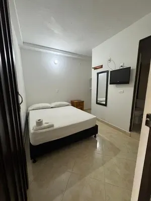 a bedroom with a bed and a tv on the wall at Hotel Real Alejandria in Alejandría