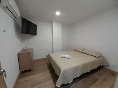 a bedroom with a bed and a flat screen tv at MEDELLIN ALOJAMIENTO EN Laureles in Medellín