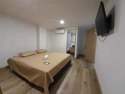 a bedroom with a bed and a flat screen tv at MEDELLIN ALOJAMIENTO EN Laureles in Medellín