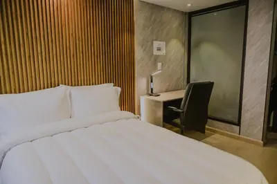 a bedroom with a bed and a desk with a chair at Torre U kooliving in Manizales