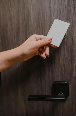 a hand holding a piece of paper on a door handle at Torre U kooliving in Manizales