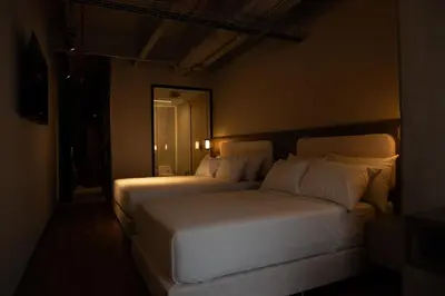 a bedroom with two beds in a dark room at Uukam by Bernalo Hotels in Medellín