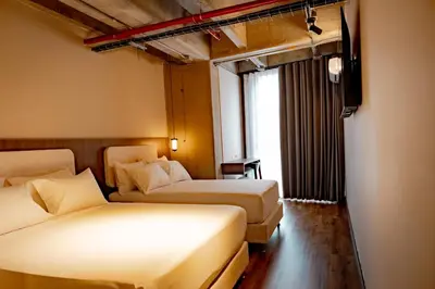 a hotel room with two beds and a window at Uukam by Bernalo Hotels in Medellín