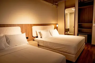 a hotel room with two beds and a mirror at Uukam by Bernalo Hotels in Medellín