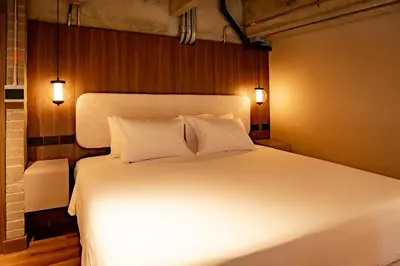 a bedroom with a white bed with two pillows at Uukam by Bernalo Hotels in Medellín