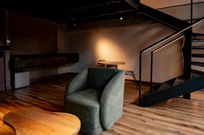 a room with a chair and a table and a piano at Uukam by Bernalo Hotels in Medellín