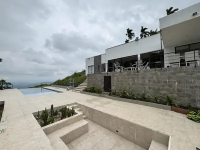 a large house with a patio and a building at Casa Campestre con Piscina in Manizales