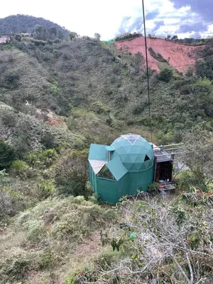 a green tent on the side of a hill at Ikuna Luxury Glamping 1h from Medellin with Private Jacuzzi in San Vicente
