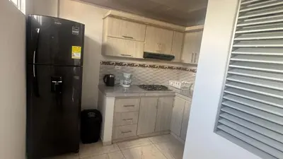 a kitchen with a black refrigerator and wooden cabinets at torre linares 1 in Manizales