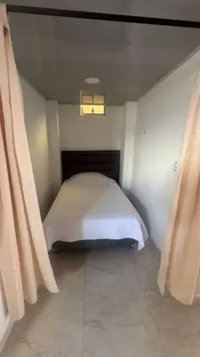 a small bed in a room with a window at torre linares 1 in Manizales