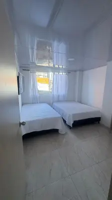 a white room with a bed and a window at torre linares 1 in Manizales