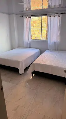 two beds in a room with a window at torre linares 1 in Manizales