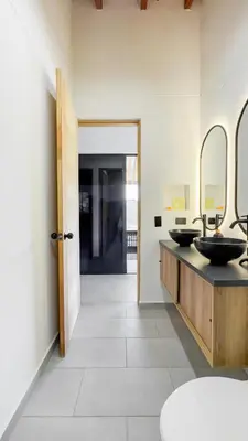 a bathroom with two sinks and two mirrors at Finca Monteverde House in San Isidro