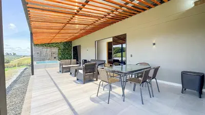 a patio with a table and chairs on it at Finca Monteverde House in San Isidro