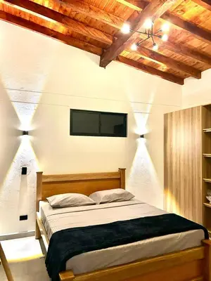 a bedroom with a bed and a flat screen tv at Finca Monteverde House in San Isidro