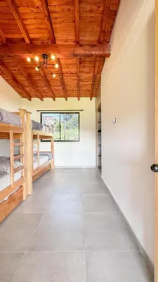 a room with bunk beds and a wooden ceiling at Finca Monteverde House in San Isidro